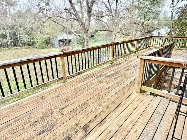 a view of balcony with wooden floor and fence