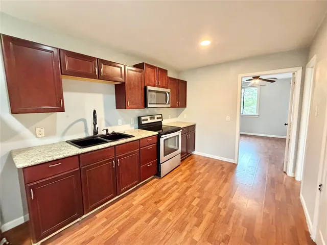 a kitchen with stainless steel appliances granite countertop a sink stove and cabinets
