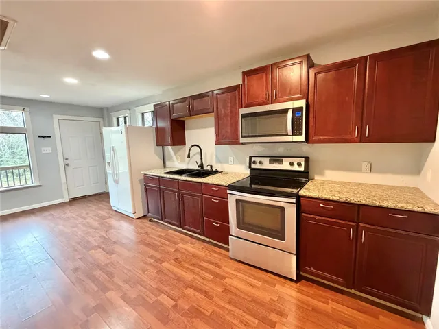 a kitchen with granite countertop a stove top oven and sink