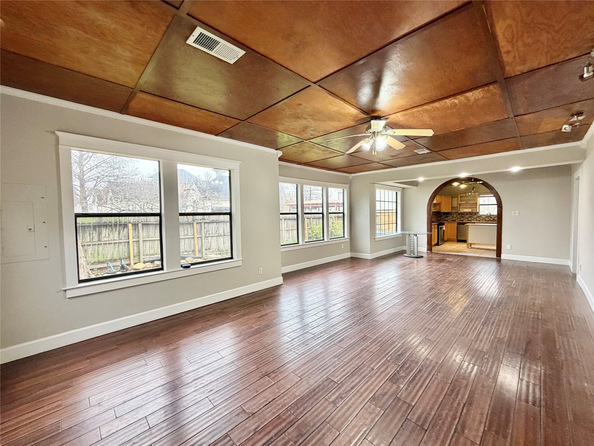 6219 Hamblen Drive Houston, TX 77396 - Photo 6 of 26 This inviting living room boasts stunning hardwood floors, abundant natural light from large windows, and a stylish wooden ceiling, seamlessly connecting to an open kitchen for effortless entertaining.