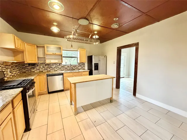 a large white kitchen with a stove a sink and a refrigerator