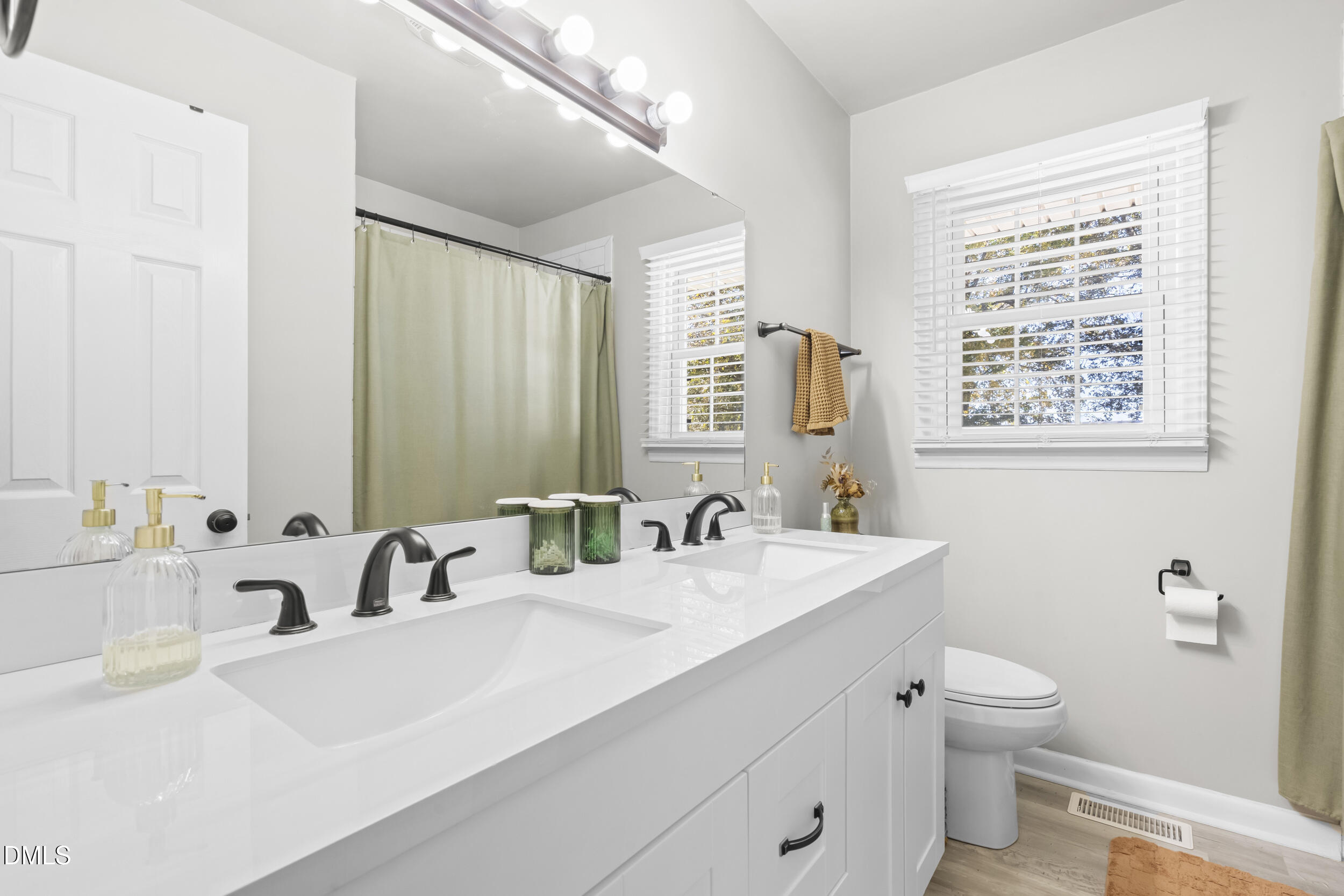 3032 Rosinburg Road Zebulon, NC 27597 - Photo 21 of 28 a bathroom with a sink a toilet and a large mirror