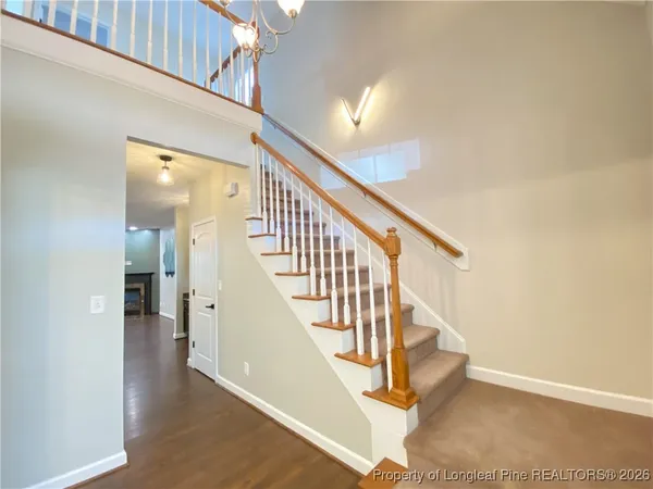 a view of staircase with lots of frames on wall and wooden floor