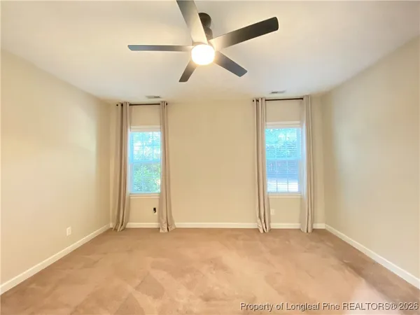 an empty room with fan and windows