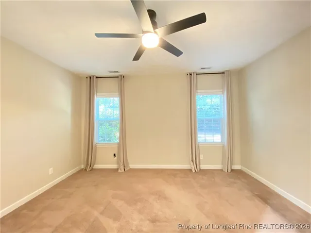 an empty room with fan and windows