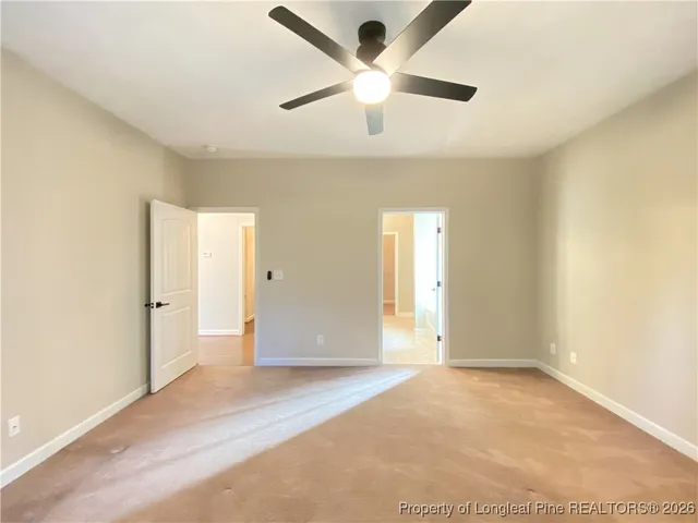 an empty room with fan and windows
