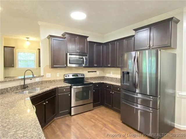 a kitchen with stainless steel appliances granite countertop a refrigerator stove and sink