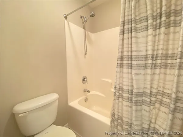a white toilet sitting next to a bath tub
