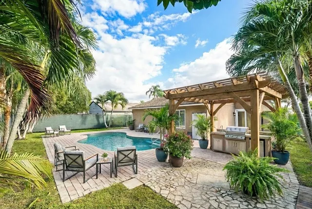 a view of a house with backyard and sitting area