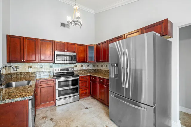 a kitchen with stainless steel appliances granite countertop a refrigerator stove and oven