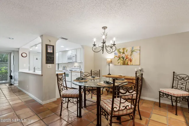 a view of a dining room with furniture a chandelier and wooden floor