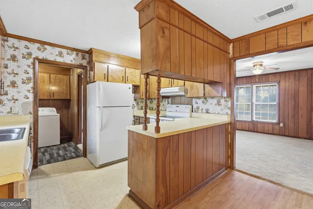 a kitchen with refrigerator and cabinets