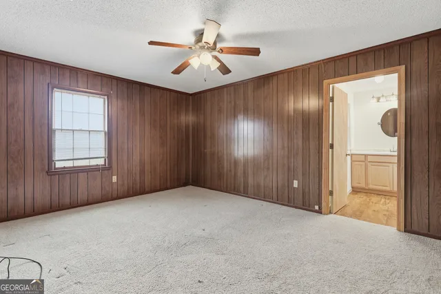a view of an empty room with a chandelier fan