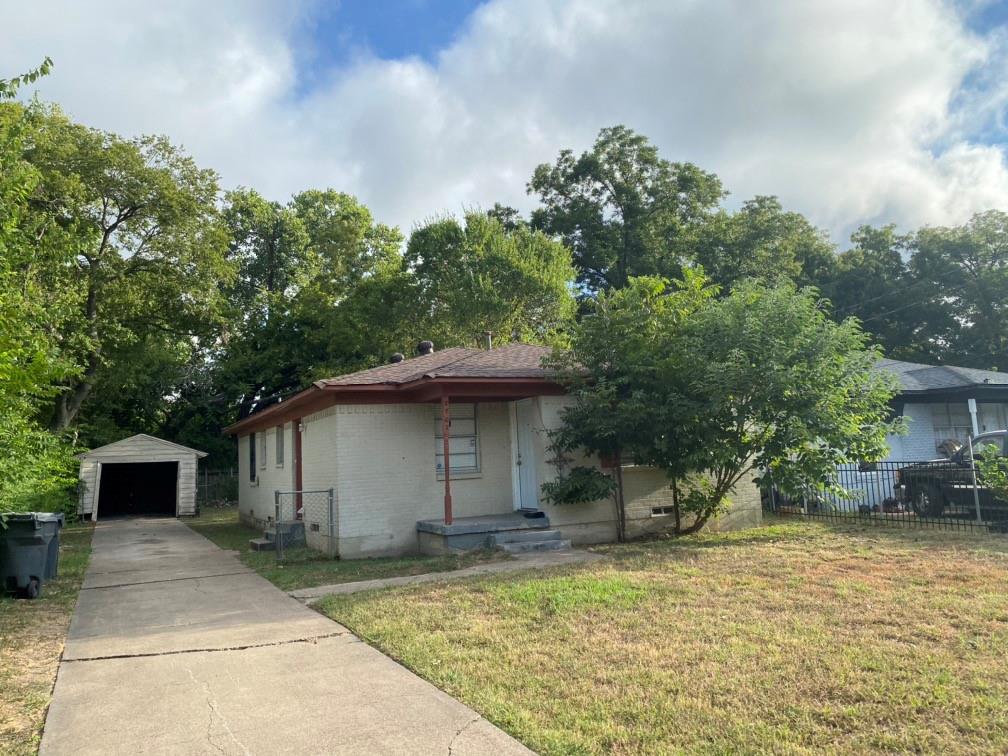 8707 Slay Street Dallas, TX 75217 - Photo 1 of 1 a backyard of a house with table and chairs under an umbrella