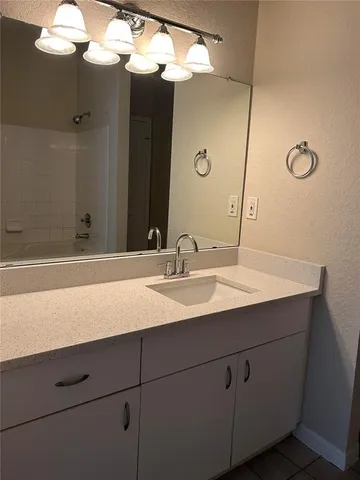 a bathroom with a sink vanity granite and a mirror