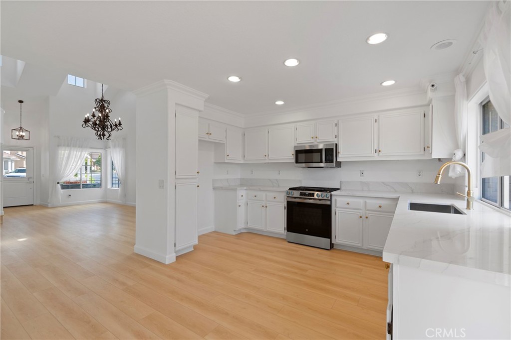 22 Carriage Drive Lake Forest, CA 92610 - Photo 6 of 35 a kitchen with granite countertop white cabinets and stainless steel appliances