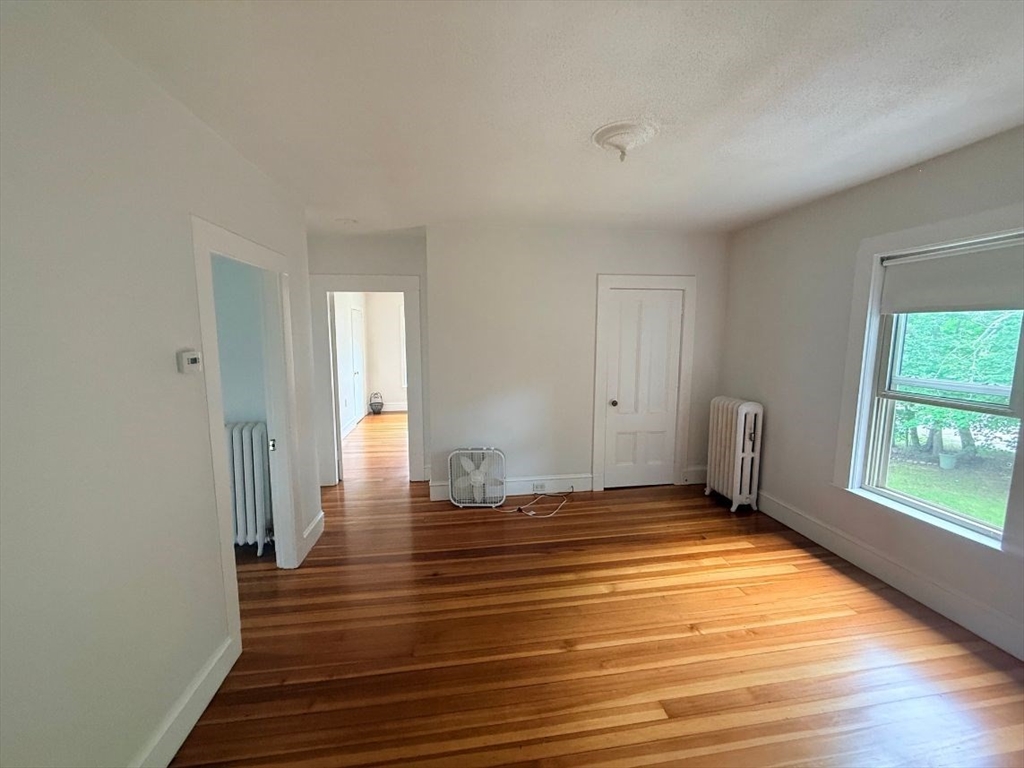 0 Cedar Street, Unit 2 Dedham, MA 02026 - Photo 9 of 11 a view of an empty room with wooden floor and a window