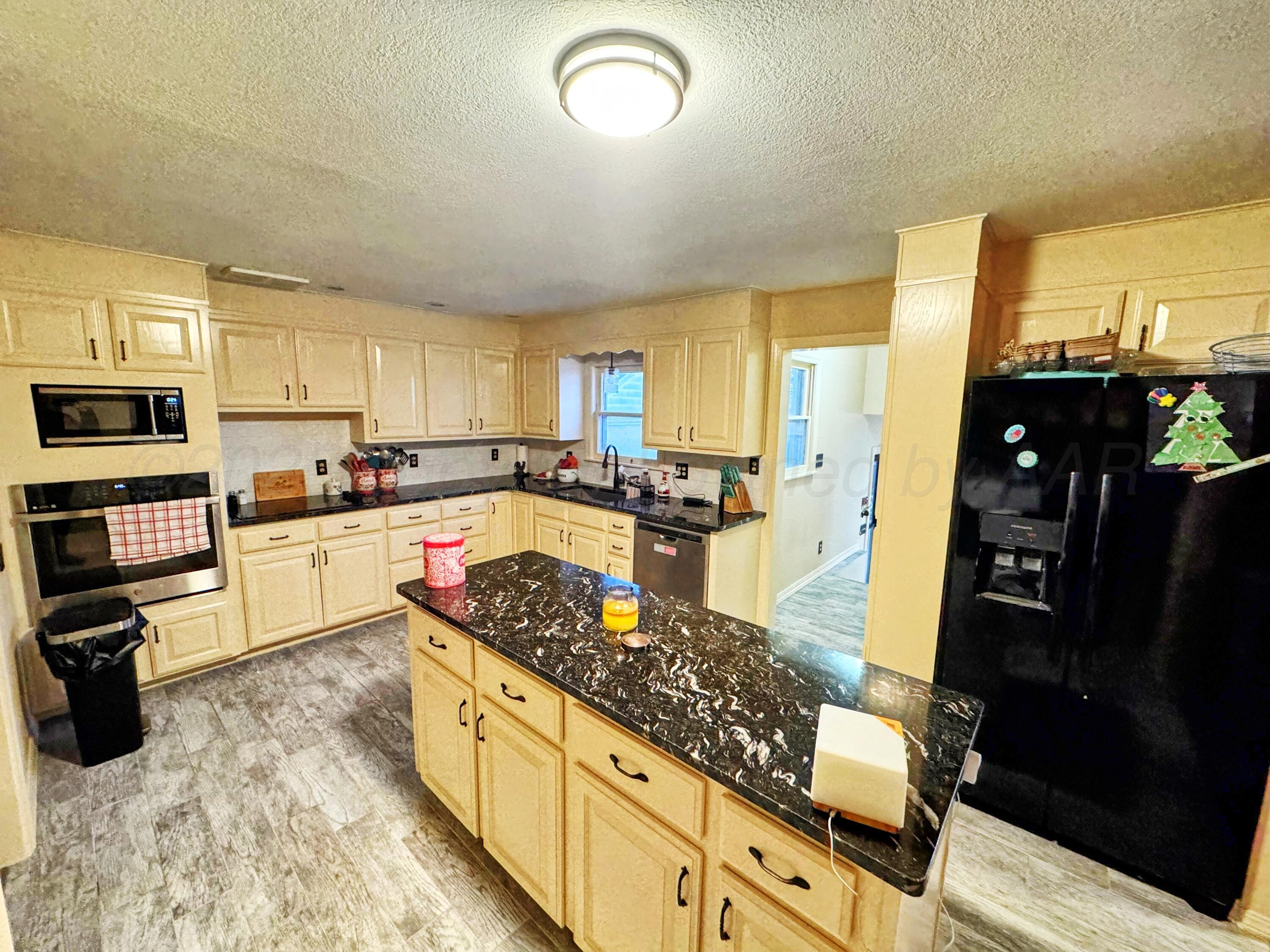 14490 County Road 24 Perryton, TX 79070 - Photo 7 of 28 a kitchen with stainless steel appliances granite countertop a stove top oven a sink a counter space and cabinets