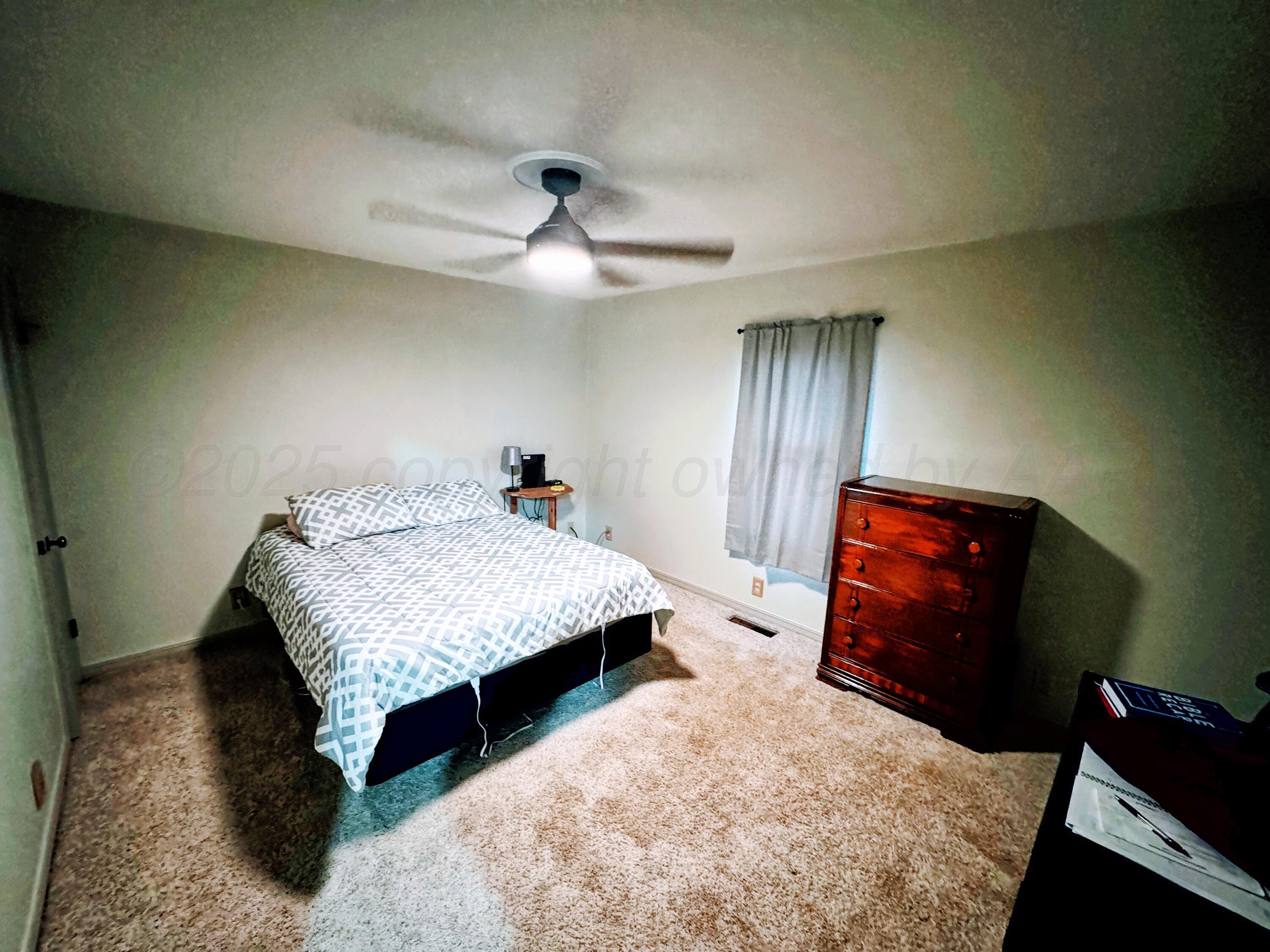14490 County Road 24 Perryton, TX 79070 - Photo 9 of 28 a bedroom with a bed and dresser with mirror