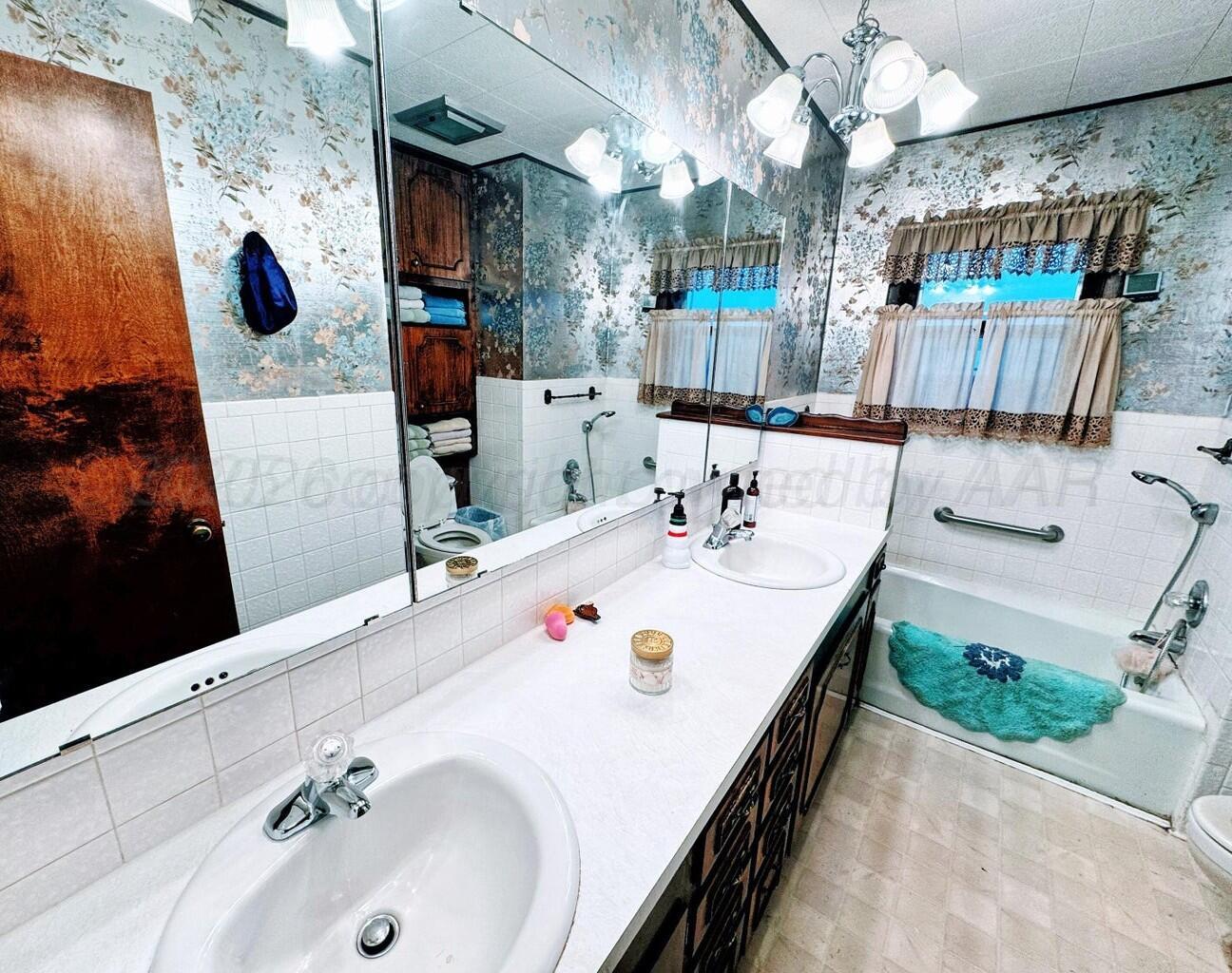 14490 County Road 24 Perryton, TX 79070 - Photo 10 of 28 a en suite bathroom with a sink and a mirror