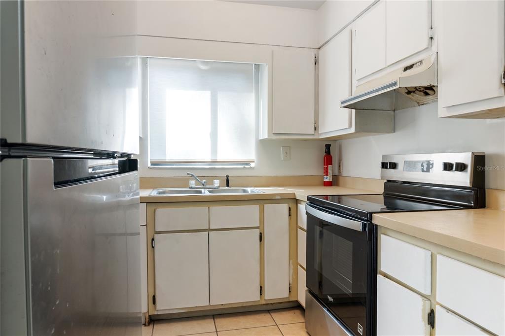 1031 Southwest 61st Street Gainesville, FL 32607 - Photo 9 of 17 a kitchen with stainless steel appliances granite countertop a sink stove and refrigerator