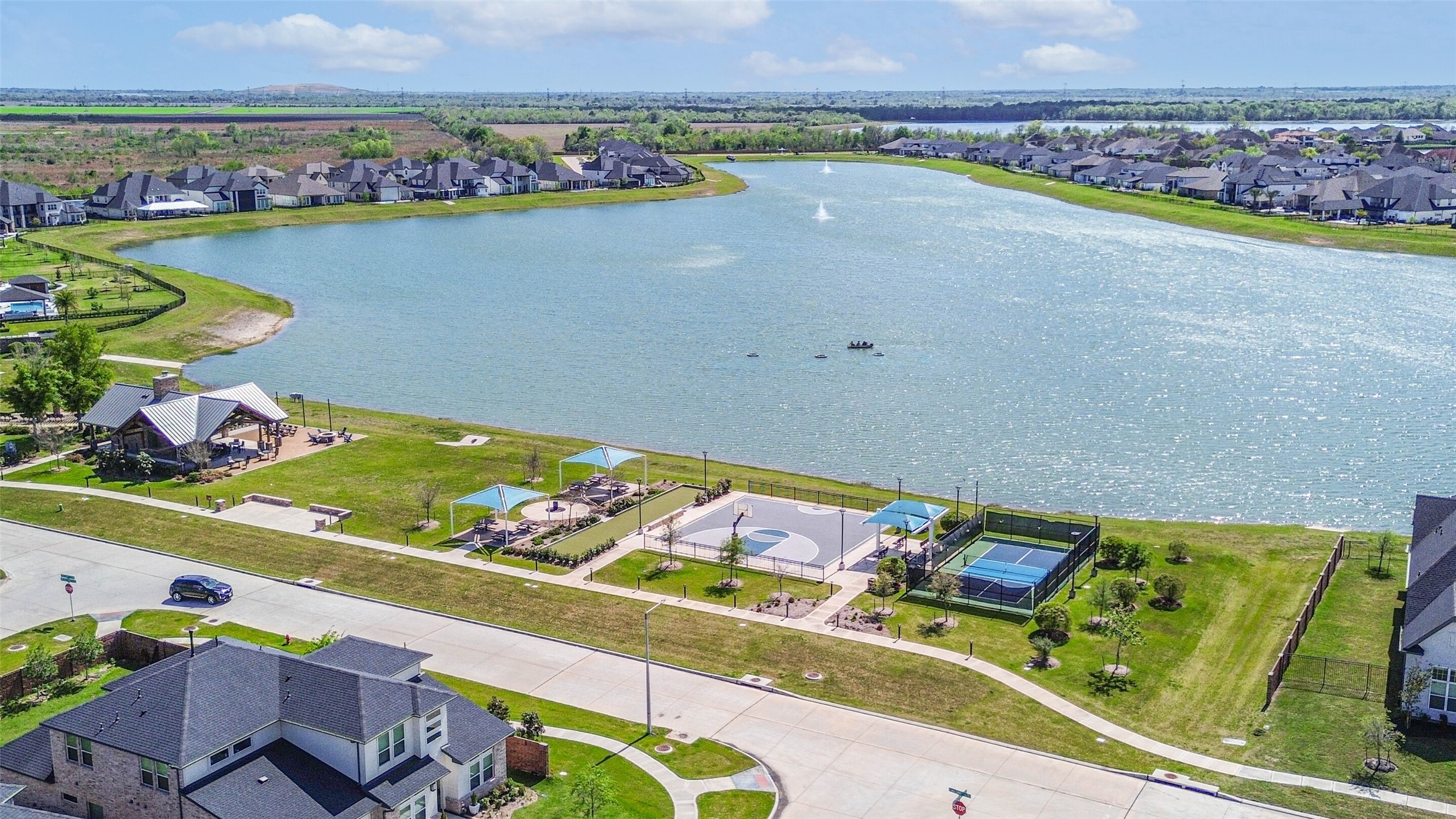 1612 Dayton Rdg Circle Friendswood, TX 77546 - Photo 4 of 50 Come join this serene lakeside community with modern homes. Amenities include a covered pavilion, basketball court, and tennis court, all set against a picturesque water view. Ideal for outdoor enthusiasts and families seeking a vibrant neighborhood.