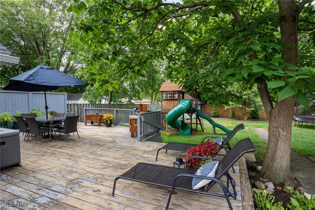 22250 Mastick Road Cleveland, OH 44126 - Photo 35 of 40 Wooden deck featuring outdoor dining area, a fenced backyard, and a playground