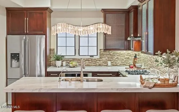 a kitchen with stainless steel appliances kitchen island granite countertop a refrigerator and a stove