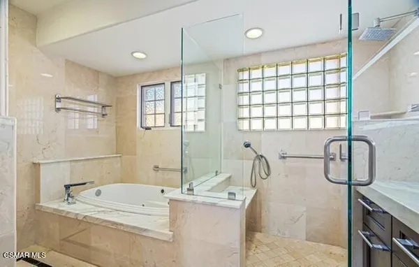 a bathroom with a granite countertop sink a large mirror and a bathtub