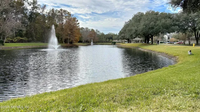 a view of a lake with a yard and trees