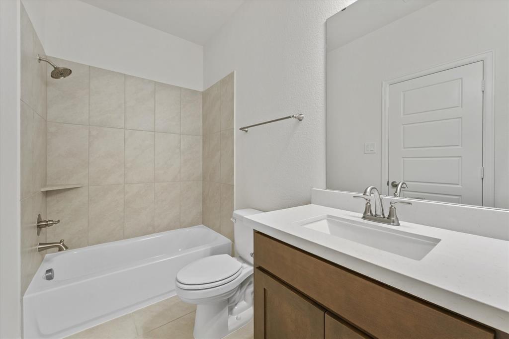 4626 Rillstone Road Midlothian, TX 76065 - Photo 29 of 40 Bathroom featuring shower / washtub combination, vanity, light tile patterned flooring, and a textured wall