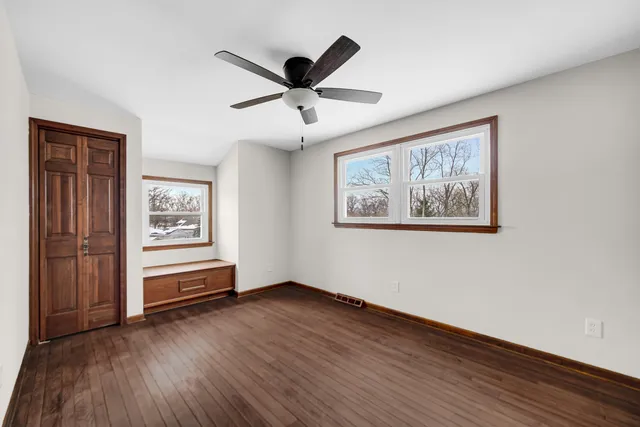 a view of empty room with wooden floor and window