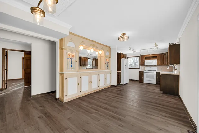 a view of a kitchen with wooden floor and electronic appliances