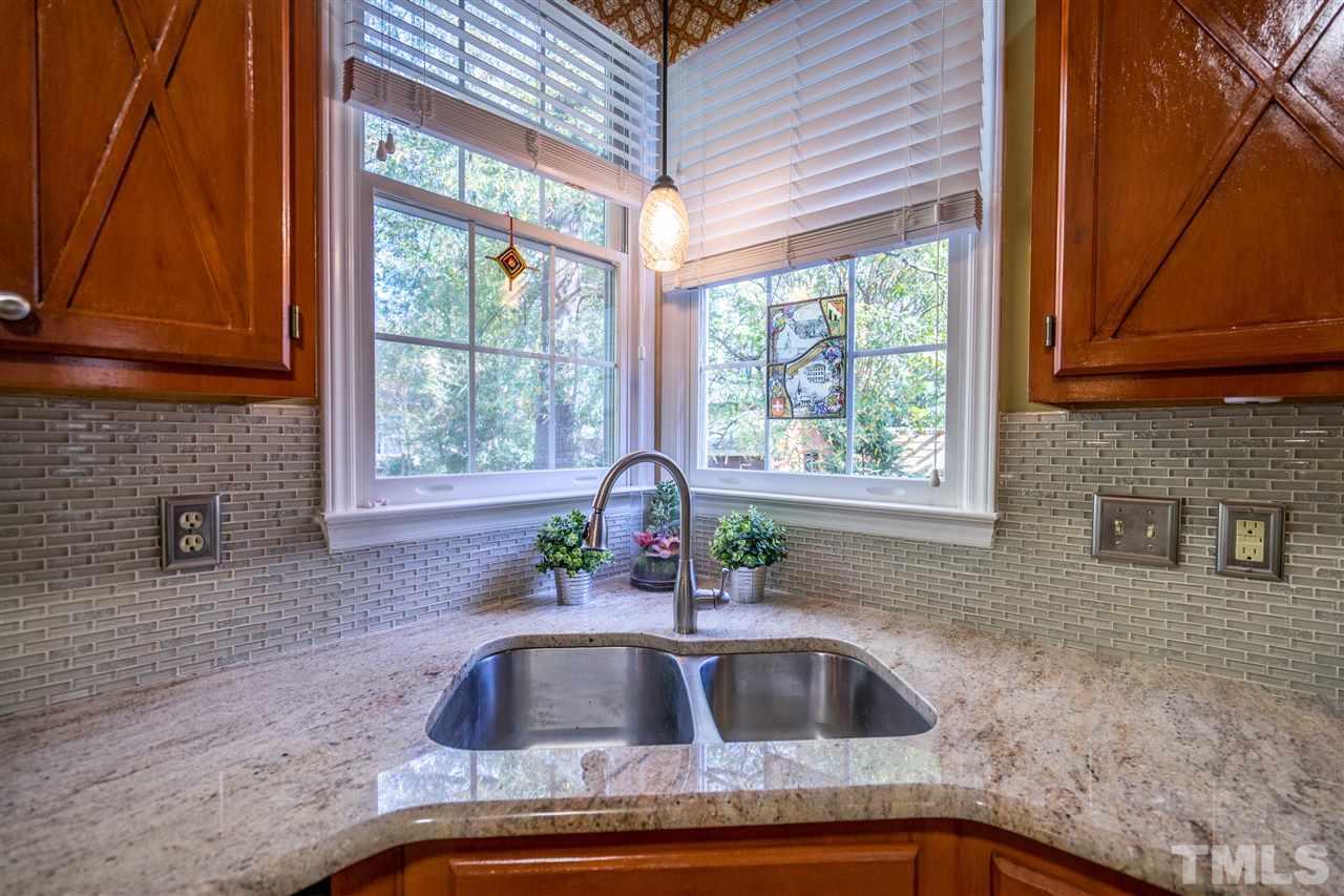 11912 Fairlie Place Raleigh, NC 27613 - Photo 13 of 25 a kitchen with granite countertop a sink and a window