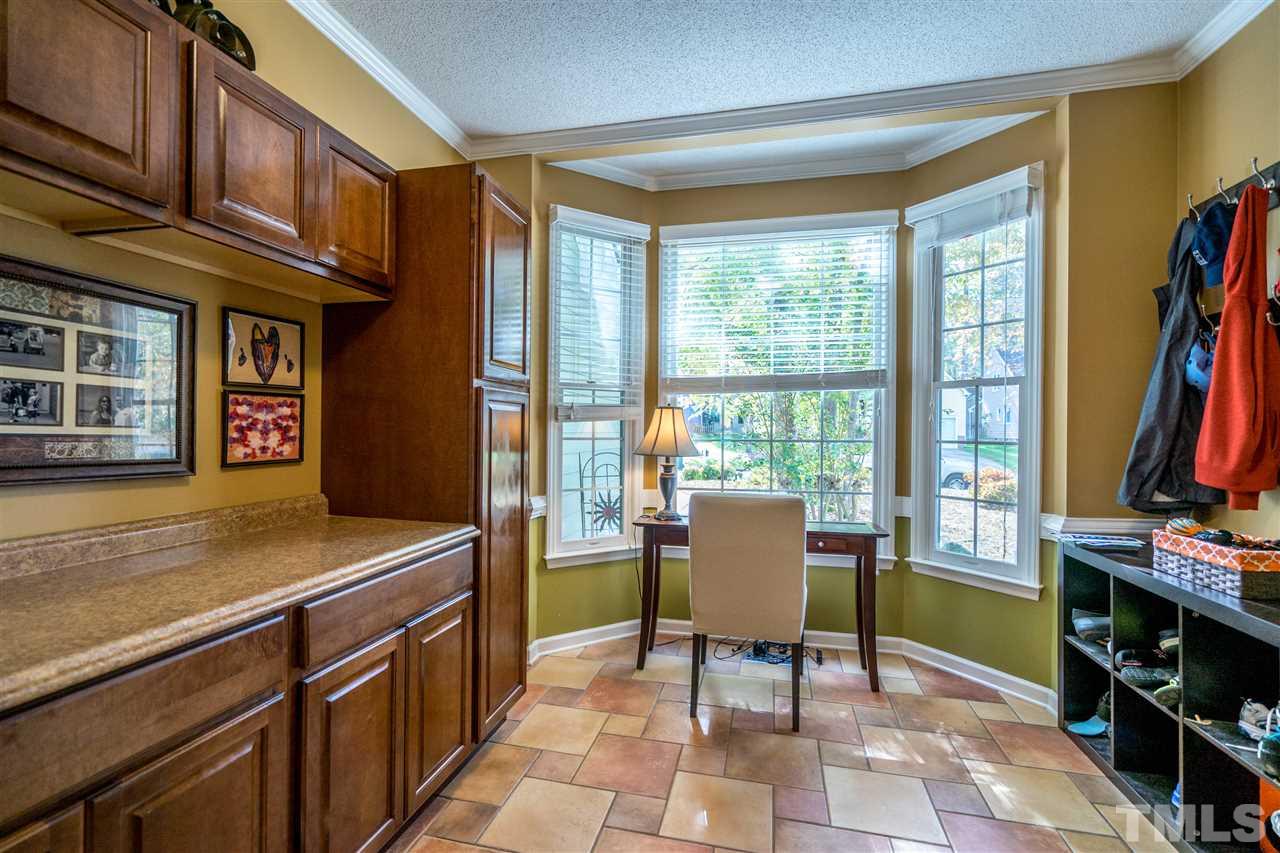 11912 Fairlie Place Raleigh, NC 27613 - Photo 16 of 25 a dining room with furniture and a flat screen tv