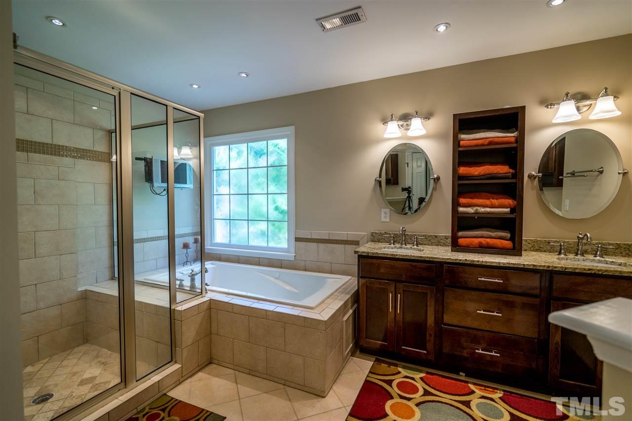 11912 Fairlie Place Raleigh, NC 27613 - Photo 19 of 25 a bathroom with a double vanity sink mirror and bathtub