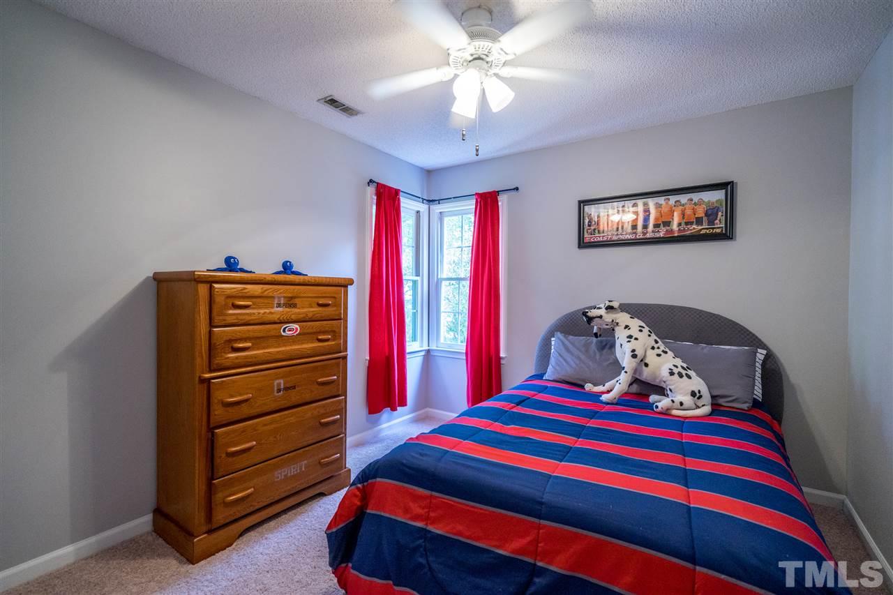 11912 Fairlie Place Raleigh, NC 27613 - Photo 21 of 25 a bedroom with a bed and a dresser