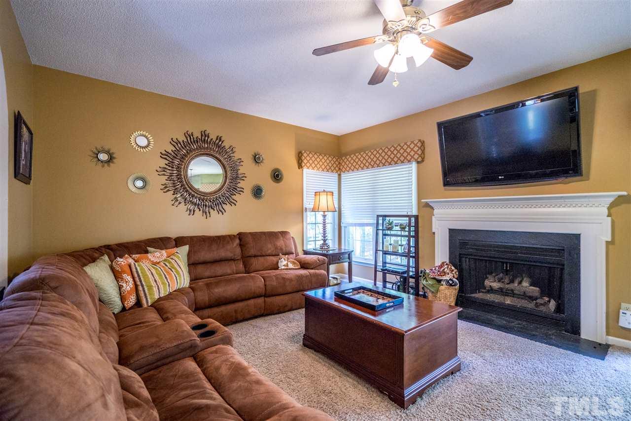 11912 Fairlie Place Raleigh, NC 27613 - Photo 8 of 25 a living room with furniture and a flat screen tv