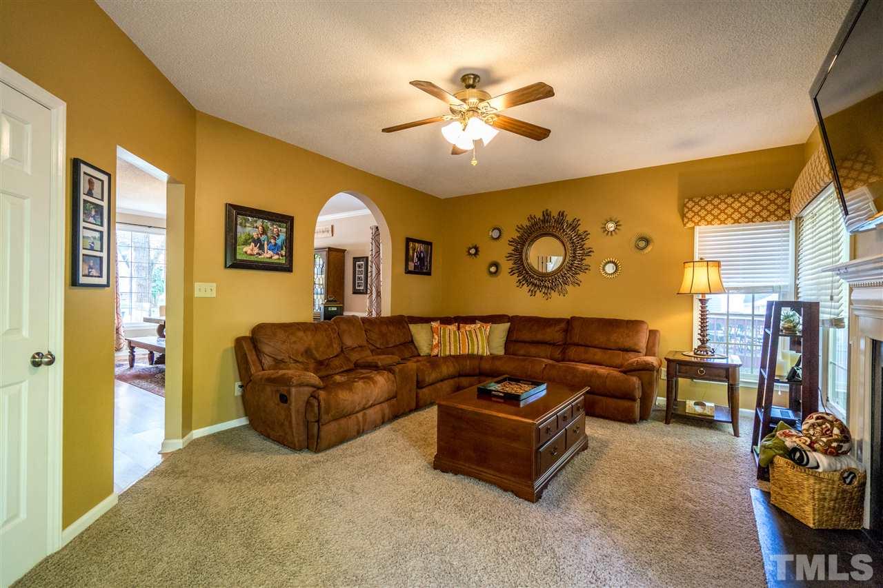 11912 Fairlie Place Raleigh, NC 27613 - Photo 9 of 25 a living room with furniture and a chandelier