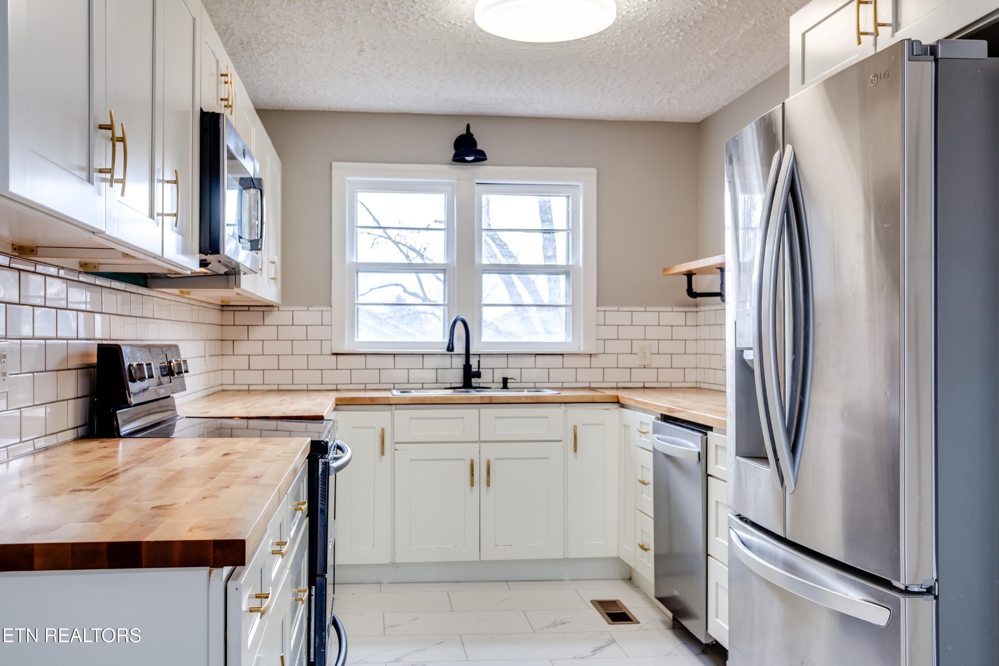 5715 Brown Gap Road Knoxville, TN 37918 - Photo 7 of 37 a kitchen with stainless steel appliances granite countertop a refrigerator a sink a stove a table and chairs