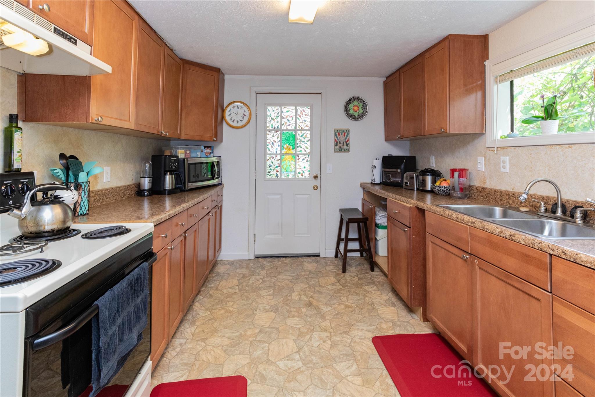 1245 Pine Spring Drive Hendersonville, NC 28739 - Photo 6 of 20 a kitchen with stainless steel appliances granite countertop a sink stove refrigerator and cabinets