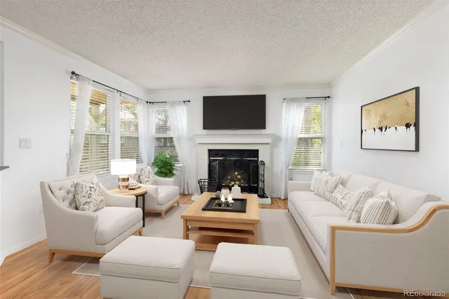 a living room with furniture fireplace and a large window