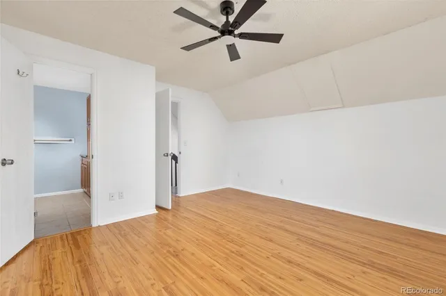 a view of a room with wooden floor and a ceiling fan