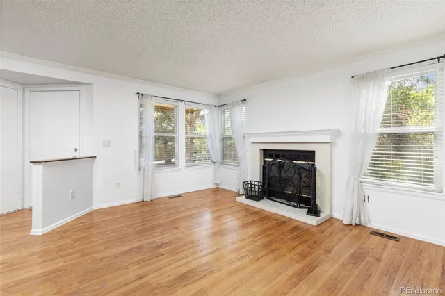 a view of an empty room with a window and fireplace