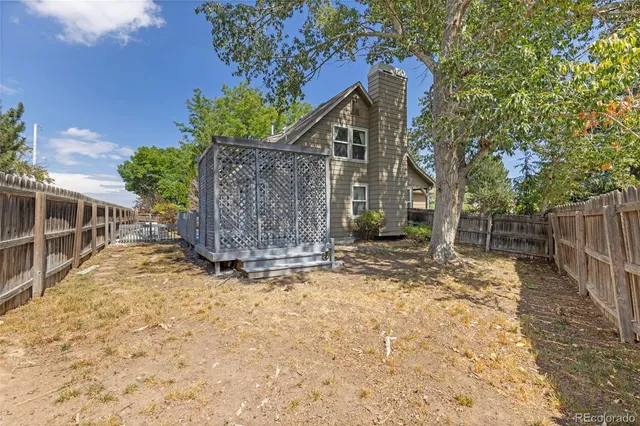 a view of a yard with wooden fence