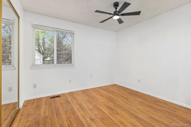 an empty room with a window and a ceiling fan