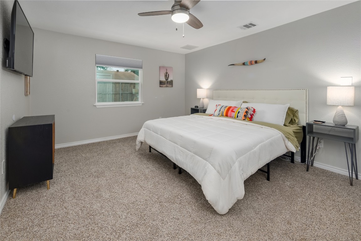 1651 Chippeway Lane Austin, TX 78745 - Photo 14 of 26 a bedroom with a bed and a chandelier
