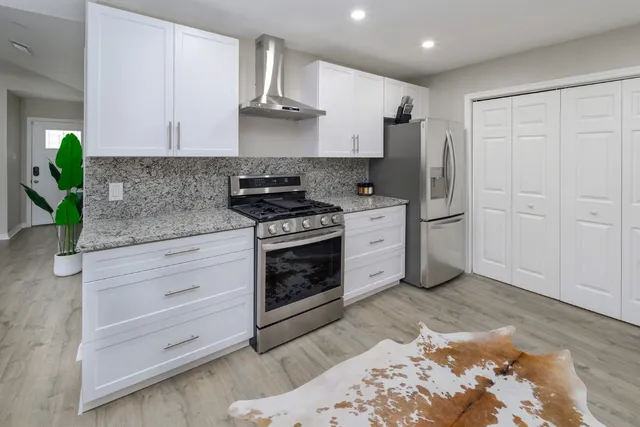 a kitchen with white cabinets and appliances