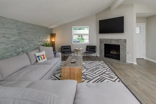 a living room with furniture a fireplace and a flat screen tv