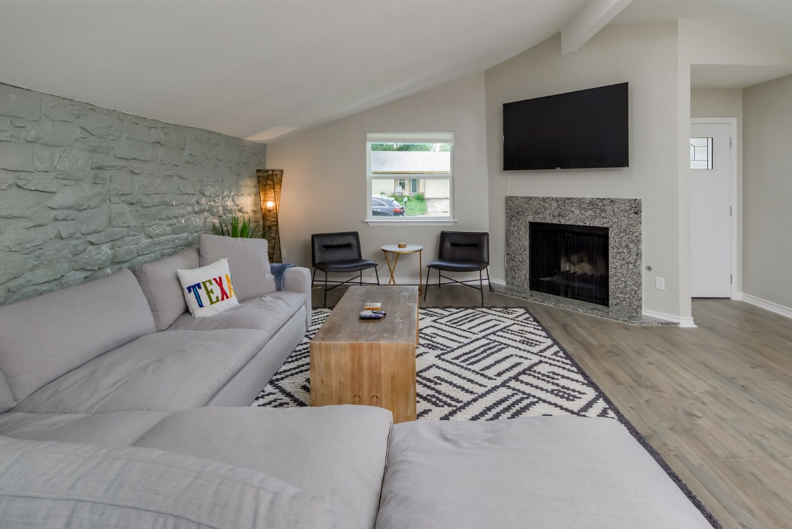 1651 Chippeway Lane Austin, TX 78745 - Photo 6 of 26 a living room with furniture a fireplace and a flat screen tv